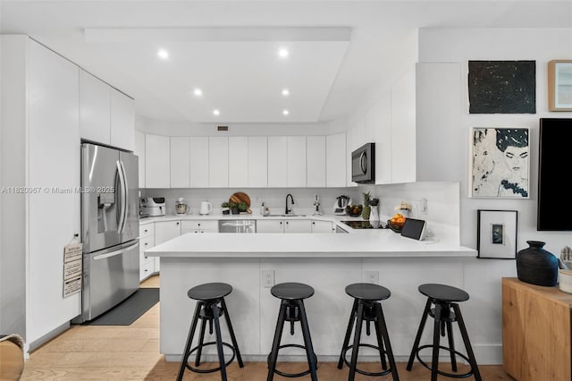 141 Crandon Blvd Unit 237, Key Biscayne, FL 33149 - kitchen with stainless steel appliances, a peninsula, light countertops, recessed lighting, and a breakfast bar area