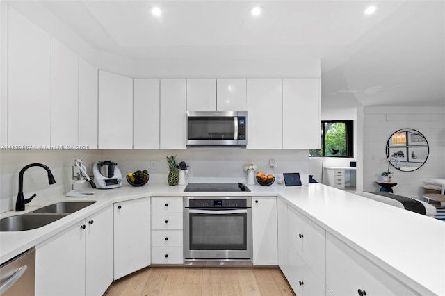 141 Crandon Blvd Unit 237, Key Biscayne, FL 33149 - kitchen featuring appliances with stainless steel finishes, light countertops, white cabinets, light wood-style flooring, and recessed lighting