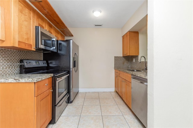 918 NE 6th St, Hallandale Beach, FL 33009 - kitchen featuring stainless steel appliances, backsplash, light tile patterned flooring, and light stone counters