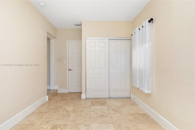 918 NE 6th St, Hallandale Beach, FL 33009 - unfurnished bedroom featuring baseboards and a closet