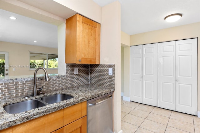 918 NE 6th St, Hallandale Beach, FL 33009 - kitchen with stainless steel dishwasher, decorative backsplash, light tile patterned floors, light stone countertops, and recessed lighting