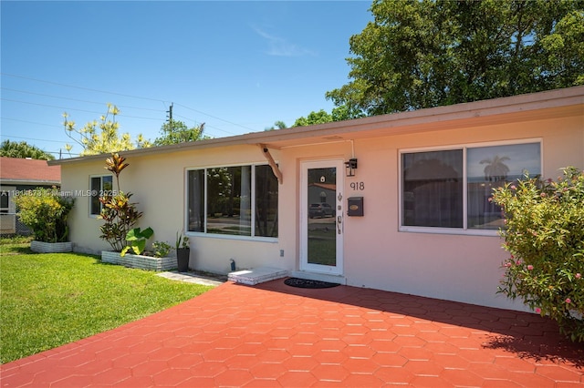 918 NE 6th St, Hallandale Beach, FL 33009 - view of front facade featuring stucco siding, a front yard, and a patio