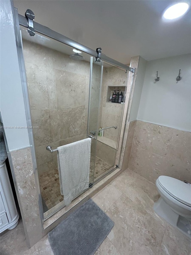 4000 NE 168th St Unit 110A, North Miami Beach, FL 33160 - bathroom with tile walls, a stall shower, and wainscoting