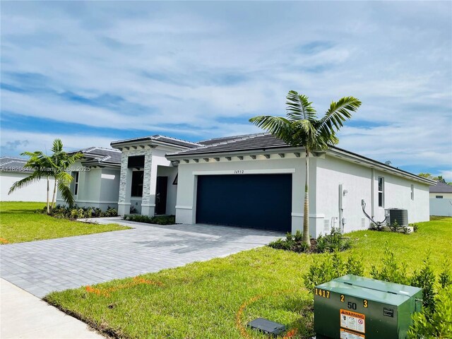 16932 SW 291st St, Homestead, FL 33030 - view of front of home with an attached garage, decorative driveway, a front lawn, and stucco siding