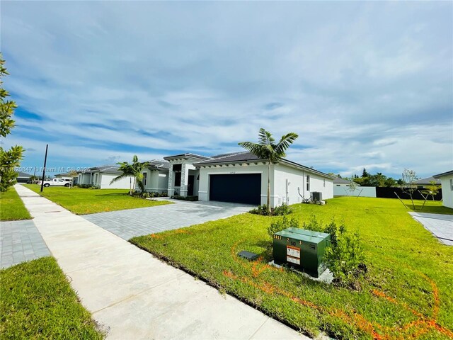 16932 SW 291st St, Homestead, FL 33030 - view of front facade featuring driveway, an attached garage, a front lawn, and stucco siding