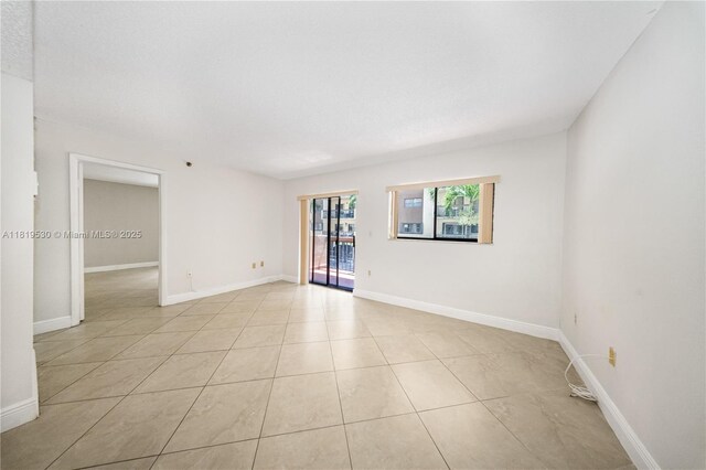 5249 NW 7th St Unit 103, Miami, FL 33126 - empty room featuring light tile patterned flooring and baseboards