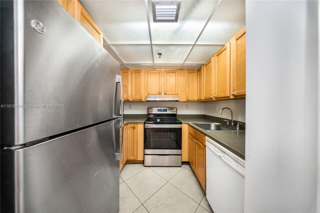5249 NW 7th St Unit 103, Miami, FL 33126 - kitchen with stainless steel appliances, under cabinet range hood, light tile patterned flooring, and dark countertops