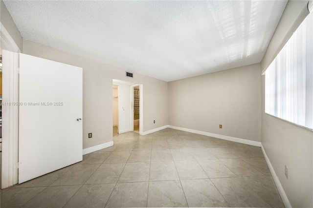5249 NW 7th St Unit 103, Miami, FL 33126 - tiled empty room with a textured ceiling and baseboards