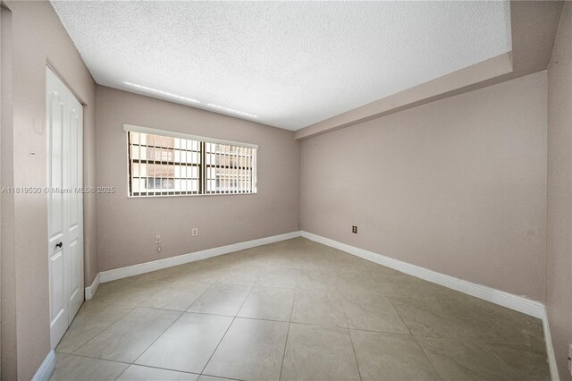 5249 NW 7th St Unit 103, Miami, FL 33126 - unfurnished bedroom featuring a textured ceiling and light tile patterned flooring