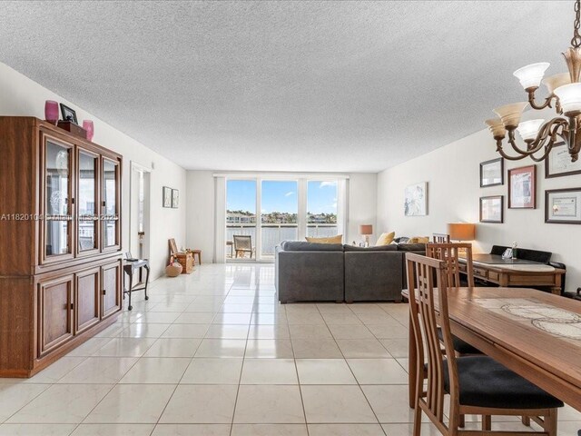 511 Bayshore Dr Unit 309, Fort Lauderdale, FL 33304 - dining space with a chandelier, a textured ceiling, light tile patterned flooring, and a water view