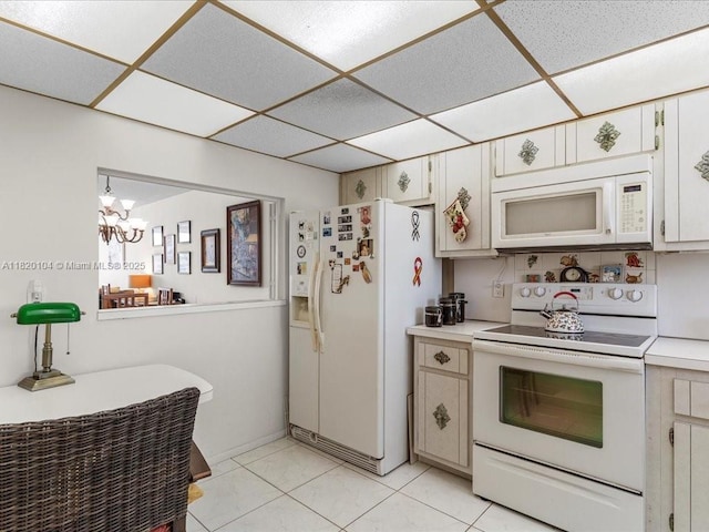 511 Bayshore Dr Unit 309, Fort Lauderdale, FL 33304 - kitchen with white appliances, a paneled ceiling, light countertops, a chandelier, and light tile patterned floors