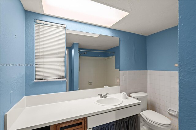 6711 N Kendall Dr Unit 505, Pinecrest, FL 33156 - bathroom with tile walls, vanity, a textured wall, a shower, and wainscoting