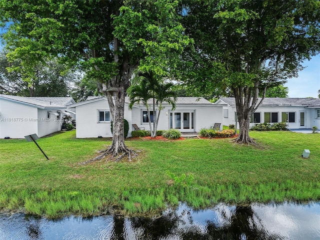 1081 NW 89th Ave, Plantation, FL 33322 - rear view of property featuring a water view, stucco siding, and a lawn