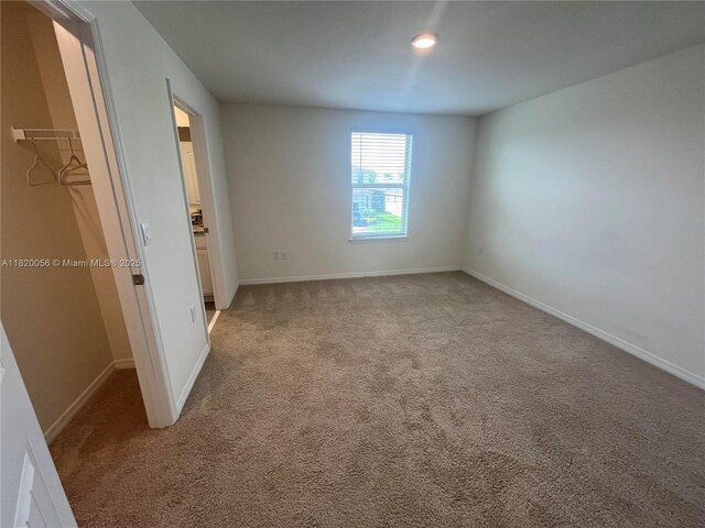 12035 Holystone St, Winter Garden, FL 34787 - unfurnished bedroom with light carpet, a walk in closet, a closet, and recessed lighting