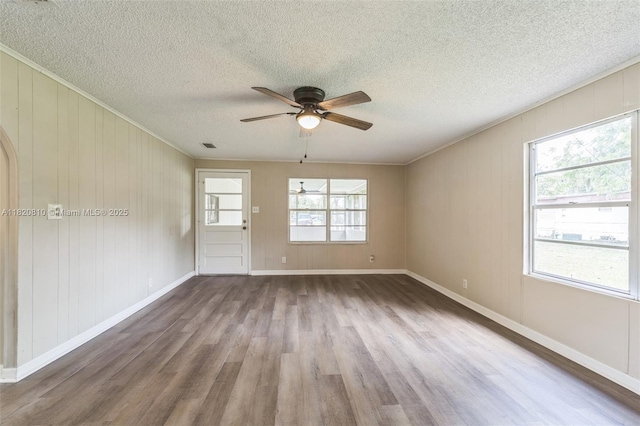 160 SW 9th Ave Fl, Lake Butler, FL 32054 - spare room featuring wood finished floors, ceiling fan, crown molding, a textured ceiling, and wooden walls