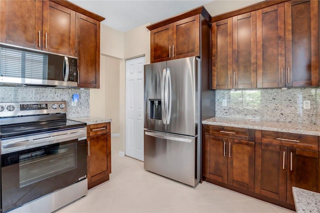 1753 Aspen Ln, Weston, FL 33327 - kitchen with appliances with stainless steel finishes, light stone countertops, backsplash, and light tile patterned floors