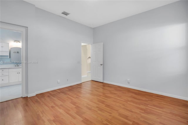 1753 Aspen Ln, Weston, FL 33327 - unfurnished bedroom featuring light wood-style flooring and connected bathroom