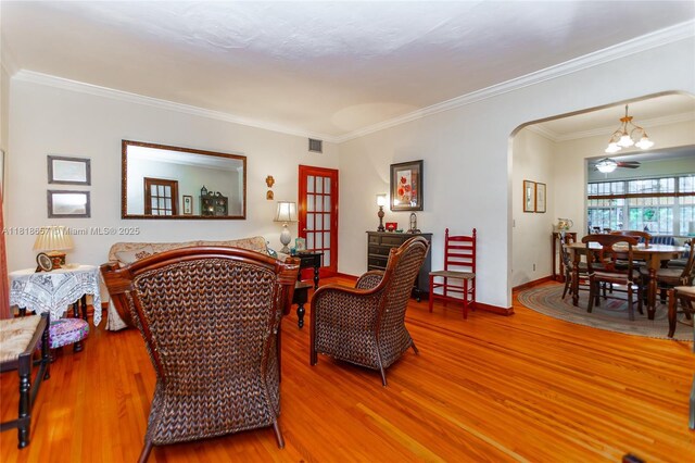 7110 SW 13th Ter, Miami, FL 33144 - living area featuring light wood-type flooring, a chandelier, crown molding, and arched walkways