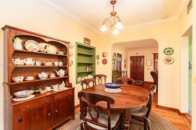 7110 SW 13th Ter, Miami, FL 33144 - dining space with arched walkways, crown molding, light wood-type flooring, and a chandelier