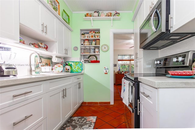 7110 SW 13th Ter, Miami, FL 33144 - kitchen featuring appliances with stainless steel finishes, open shelves, ornamental molding, white cabinetry, and dark tile patterned flooring