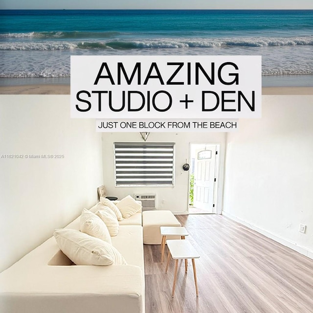 7720 Harding Ave Unit 3, Miami Beach, FL 33141 - living area featuring wood finished floors, view of water and beach, and a wall mounted air conditioner