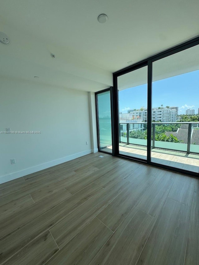 9901 W Bay Harbour Dr Unit 605, Bay Harbor Islands, FL 33154 - empty room featuring a city view, wood finished floors, and a wall of windows
