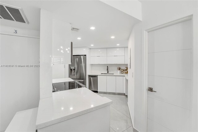 999 Brickell Bay Dr Unit 711, Miami, FL 33131 - kitchen with modern cabinets, white cabinets, stainless steel appliances, light countertops, and recessed lighting
