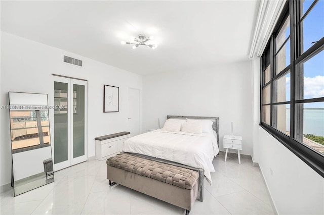 999 Brickell Bay Dr Unit 711, Miami, FL 33131 - bedroom with light tile patterned floors, a chandelier, and french doors