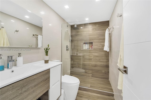 999 Brickell Bay Dr Unit 711, Miami, FL 33131 - bathroom featuring vanity, tiled shower, wood finished floors, and recessed lighting