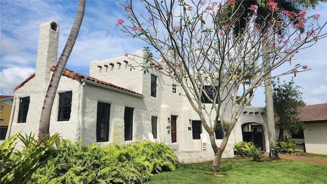 85 Deer Run, Miami Springs, FL 33166 - mediterranean / spanish home featuring a front yard, stucco siding, a chimney, and a tiled roof