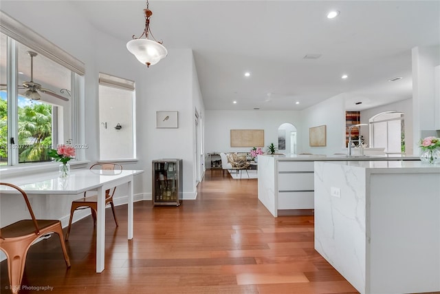 17050 SW 90th Ave, Palmetto Bay, FL 33157 - kitchen with beverage cooler, arched walkways, white cabinetry, plenty of natural light, and recessed lighting
