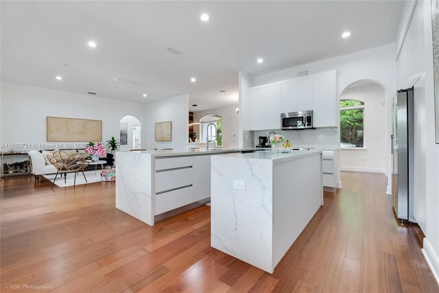 17050 SW 90th Ave, Palmetto Bay, FL 33157 - kitchen with stainless steel appliances, modern cabinets, arched walkways, a center island, and recessed lighting
