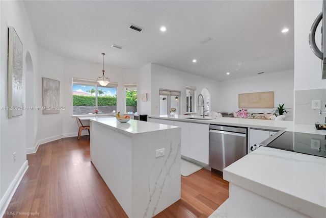 17050 SW 90th Ave, Palmetto Bay, FL 33157 - kitchen featuring modern cabinets, stainless steel dishwasher, a kitchen island, white cabinetry, and light wood-style flooring