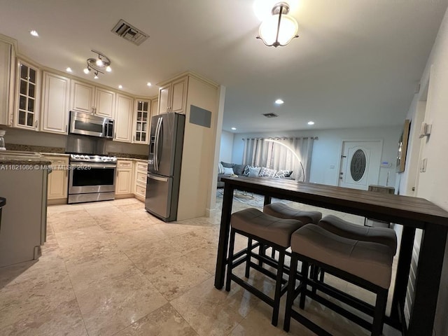 3338 Taft St, Hollywood, FL 33021 - kitchen with appliances with stainless steel finishes, cream cabinets, glass insert cabinets, recessed lighting, and dark countertops