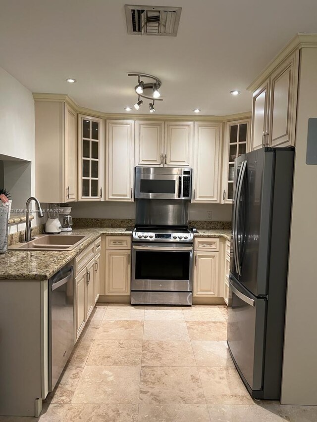 3338 Taft St, Hollywood, FL 33021 - kitchen featuring appliances with stainless steel finishes, cream cabinetry, glass insert cabinets, stone countertops, and recessed lighting