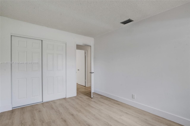 8511 NW 51st Ct, Lauderhill, FL 33351 - unfurnished bedroom featuring light wood-style floors, a textured ceiling, and a closet