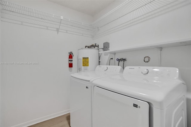 8511 NW 51st Ct, Lauderhill, FL 33351 - laundry room featuring water heater, washer and clothes dryer, and light wood-style flooring