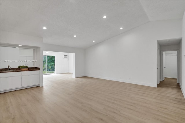 8511 NW 51st Ct, Lauderhill, FL 33351 - unfurnished living room featuring light wood-style flooring, recessed lighting, vaulted ceiling, and a textured ceiling