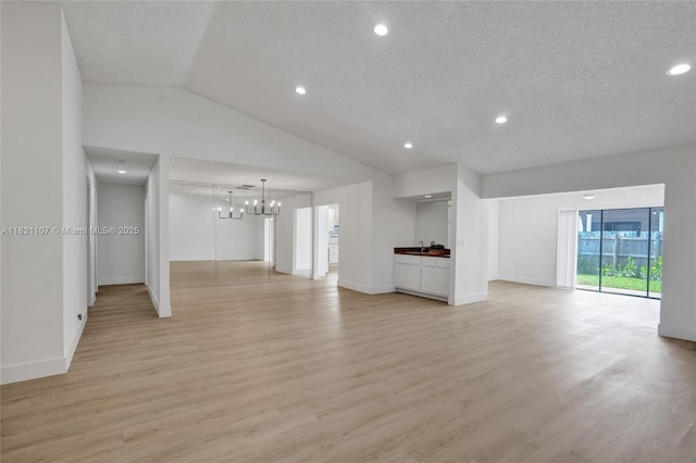 8511 NW 51st Ct, Lauderhill, FL 33351 - unfurnished living room featuring light wood-type flooring, a chandelier, a textured ceiling, recessed lighting, and vaulted ceiling