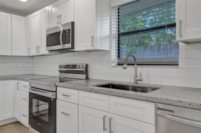 8511 NW 51st Ct, Lauderhill, FL 33351 - kitchen featuring appliances with stainless steel finishes, tasteful backsplash, and white cabinets