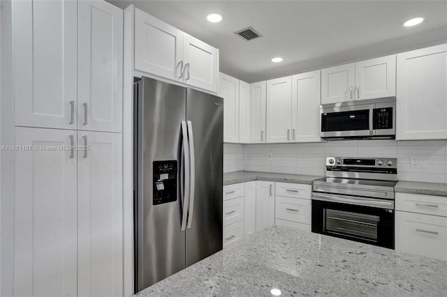 8511 NW 51st Ct, Lauderhill, FL 33351 - kitchen featuring appliances with stainless steel finishes, white cabinetry, light stone countertops, decorative backsplash, and recessed lighting