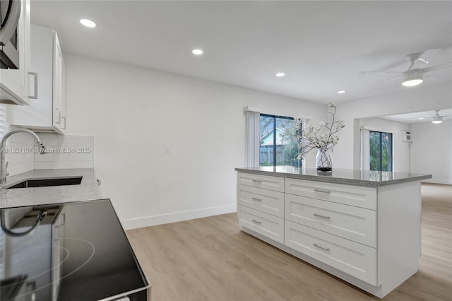 8511 NW 51st Ct, Lauderhill, FL 33351 - kitchen featuring light stone counters, ceiling fan, white cabinets, light wood-style flooring, and recessed lighting