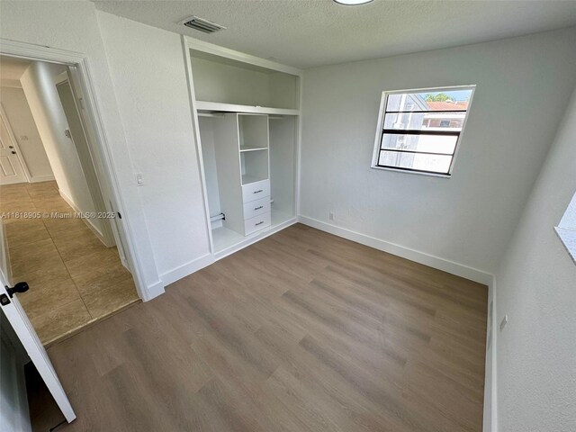 6213 NW 9th St, Margate, FL 33063 - unfurnished bedroom with a textured ceiling, a closet, and wood finished floors