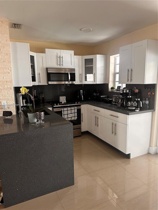 3250 NW 174th St, Miami Gardens, FL 33056 - kitchen with stainless steel appliances, tasteful backsplash, and white cabinetry