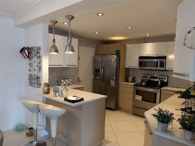 575 Crandon Blvd Unit 706, Key Biscayne, FL 33149 - kitchen with appliances with stainless steel finishes, a peninsula, light countertops, decorative backsplash, and a kitchen bar