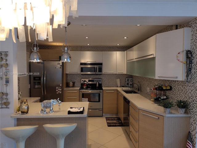 575 Crandon Blvd Unit 706, Key Biscayne, FL 33149 - kitchen with appliances with stainless steel finishes, a peninsula, hanging light fixtures, and light countertops