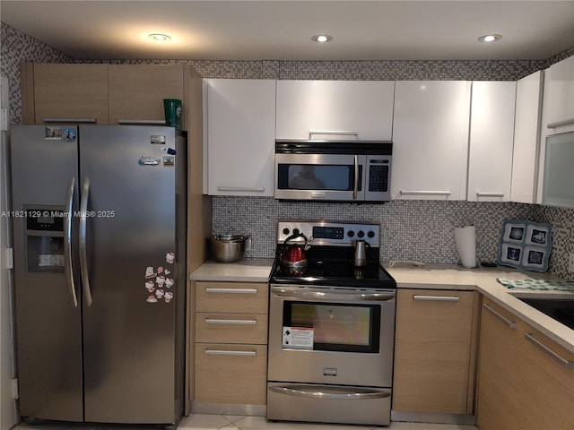 575 Crandon Blvd Unit 706, Key Biscayne, FL 33149 - kitchen with appliances with stainless steel finishes, light countertops, white cabinetry, and backsplash