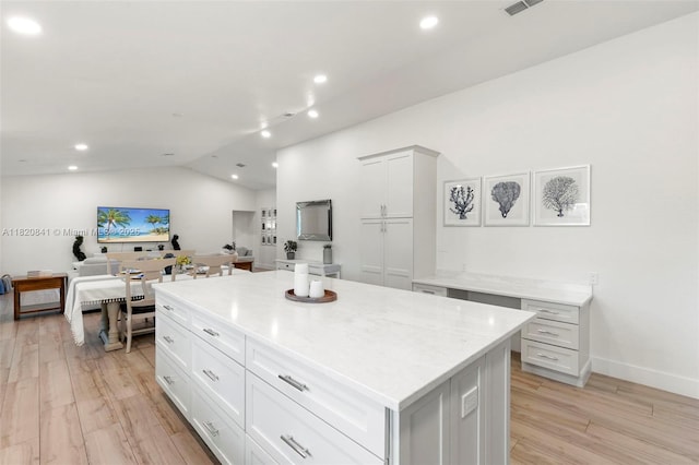1020 SW 19th St SW, Naples, FL 34117 - kitchen with vaulted ceiling, a kitchen island, light wood finished floors, recessed lighting, and white cabinets