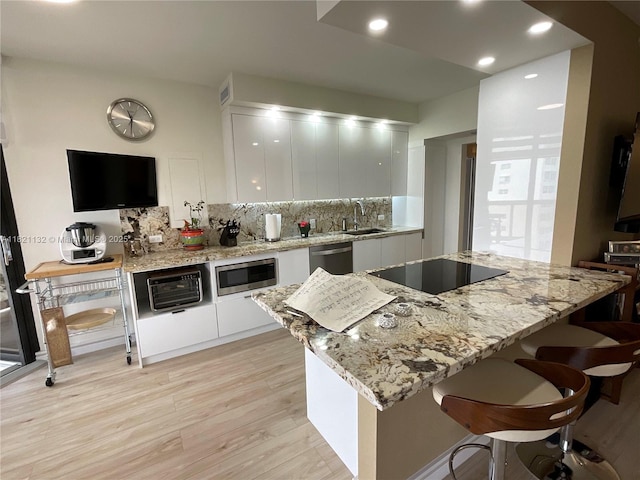 20191 E Country Club Dr Unit 1903, Aventura, FL 33180 - kitchen with modern cabinets, stainless steel appliances, light wood-style floors, white cabinets, and backsplash