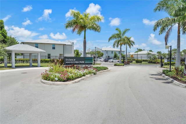 5720 Mentmore Dr, Mangonia Park, FL 33407 - view of asphalt street with a gate, curbs, a gated entry, and a residential view